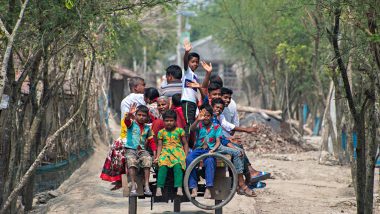 attimi di vita in un villaggio della foresta del Bengala, persone ammassate su un carretto salutano felici
